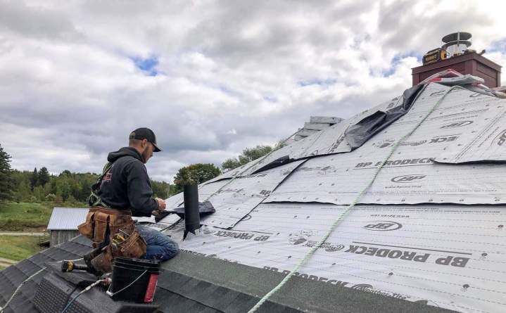 Couvreur installant une sous-couche de toiture synthétique, Lévis